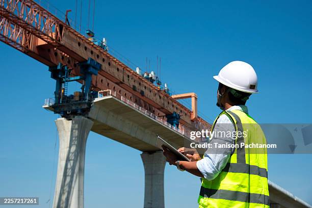 surveyors and civil engineers using a total station and construction blueprints for railway structure infrastructure." - civil engineering and construction stock pictures, royalty-free photos & images