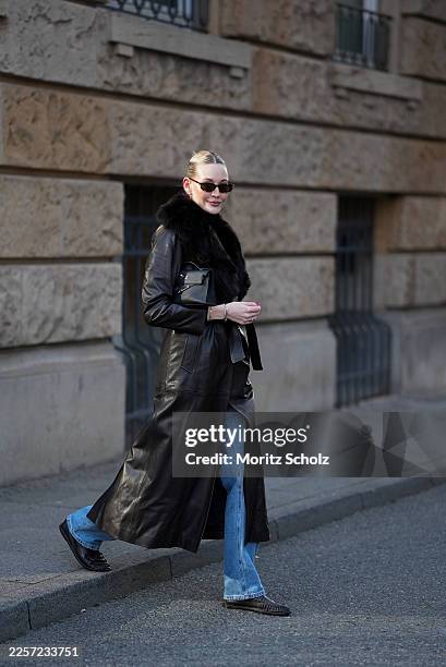 Mandy Bork is wearing a dark brown leather long coat with a belted waist, smooth leather surface and a wide dark brown fur collar from Nour Hammour;...