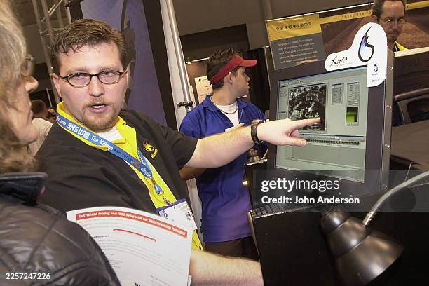 View of American entrepreneur & NewTek Vice President Philip Nelson demonstrating imaging software to an attendee during the South By Southwest Trade...
