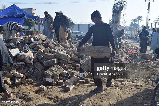 Residents inspect the damage at the site of a suicide bombing that targeted a wedding gathering in Dera Ismail Khan, Pakistan, on January 24, 2026....
