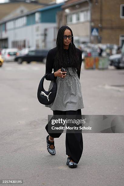 Guest is seen wearing a black crop cardigan; a black and white checkered mini dress with a gathered waist; black balloon pants; black and silver Nike...