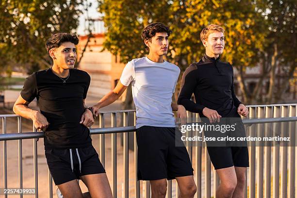young men athletes resting after outdoor training - running shorts stock pictures, royalty-free photos & images
