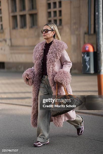 Julia Kammerer is seen wearing a long soft pink fluffy faux fur suede trench coat with oversized shaggy collar, cuffs and hem and belted waist from...