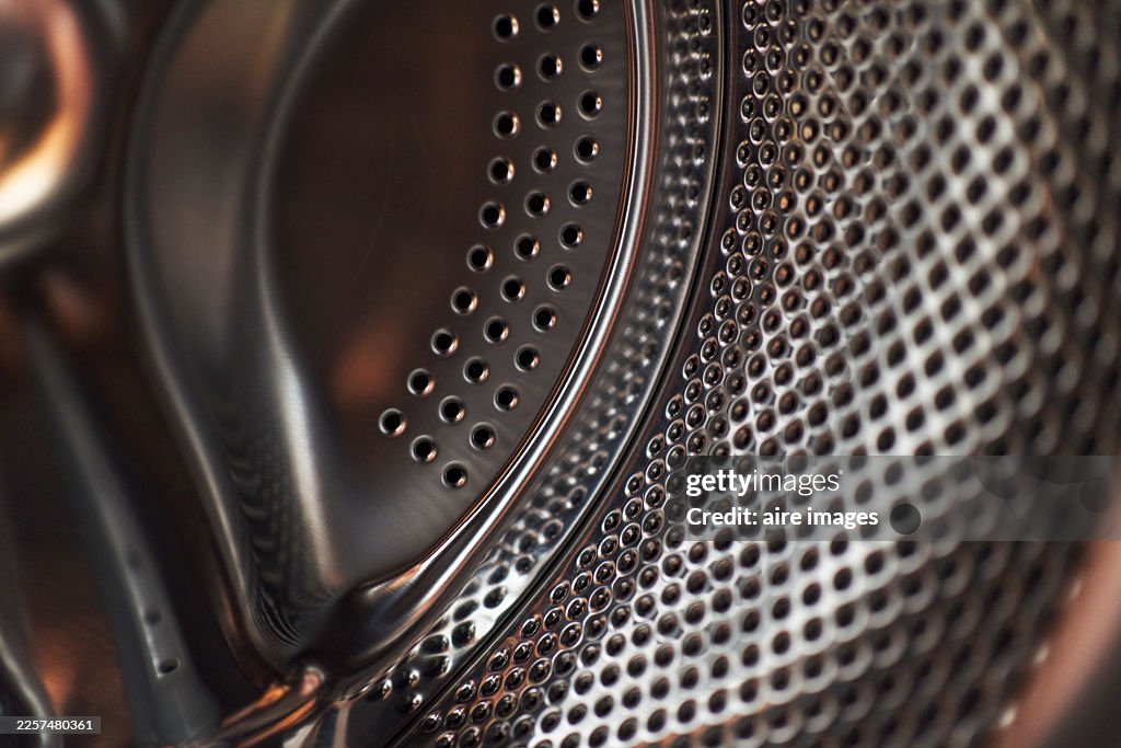 Washing machine drum interior close-up with stainless steel texture