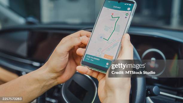 young delivery latin man using smartphone navigation to find next destination inside a van. online shopping and e-commerce concept. - car navigation system stock pictures, royalty-free photos & images