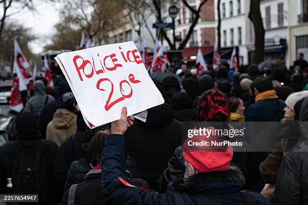 Participant holds a placard reading ''Police ICE 20th arrondissement'' during a march in tribute to 35-year-old El Hacen Diarra, who dies in police...