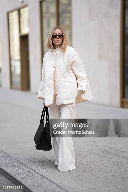 Anouk Delphine is seen wearing a thin cloud dancer white quilted puffer jacket with button front and oversized fit from The Frankie Shop; a cream...