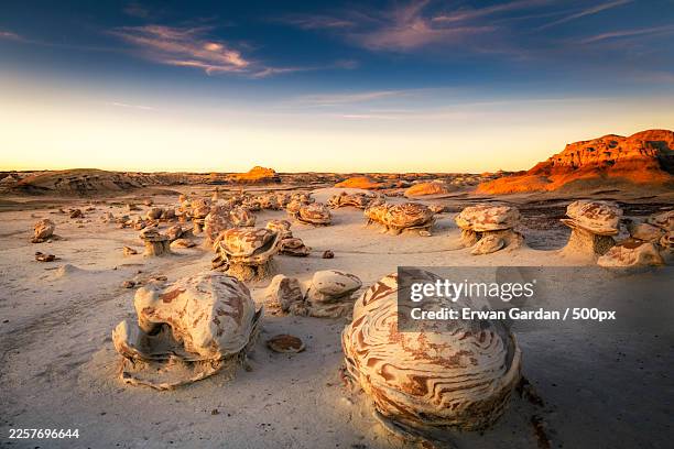 bisti badlands landscape with unique rock formations under a vibrant sunset sky,farmington,united states,usa - cheminée de fée photos et images de collection