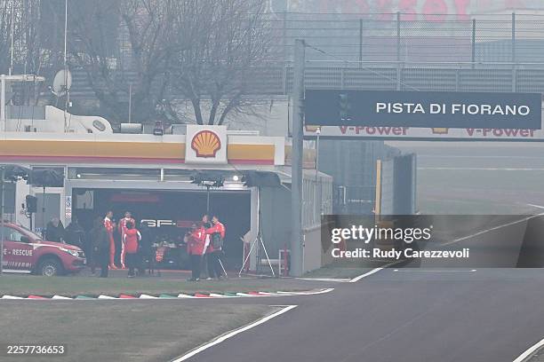Lewis Hamilton of Great Britain and Charles Leclerc of Monaco look on outside the garage prior to the first running of the SF-26 during the Scuderia...