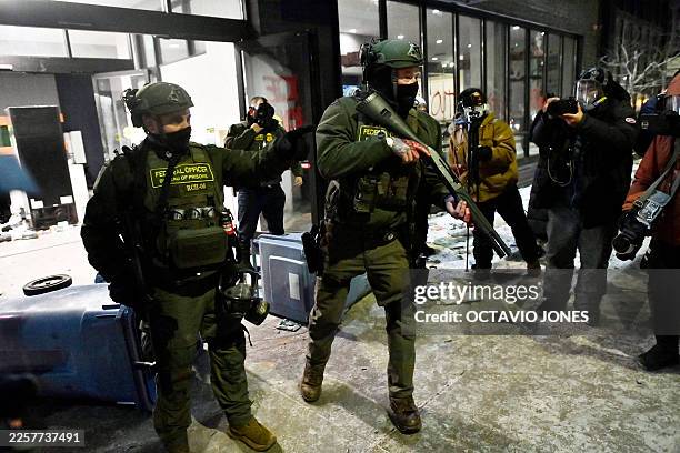 Federal agents push back protesters during the "ICE OUT! Noise Demo" outside a hotel in Minneapolis, Minnesota on January 25, 2026. On January 24,...