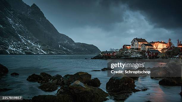 remote coastal settlement illuminated at dusk in northern norway - scandinavia stock pictures, royalty-free photos & images