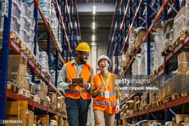 warehouse workers collaborating and laughing in logistics facility - van depot stock pictures, royalty-free photos & images
