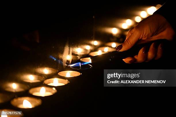 Participant lights candles during a ceremony marking International Holocaust Remembrance Day at the Jewish Museum and Tolerance Centre in Moscow on...