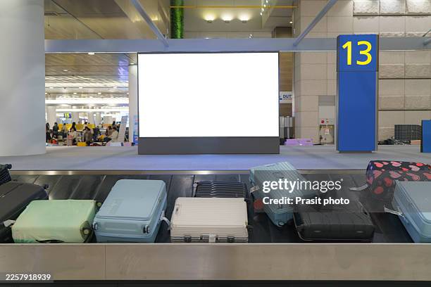 luggage and suitcases on conveyor belt at airport arrival hall - carousel stock pictures, royalty-free photos & images
