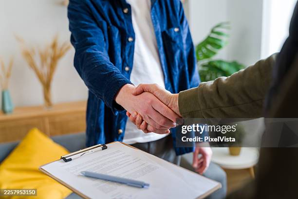 business people shaking hands over contract document - dedicação imagens e fotografias de stock