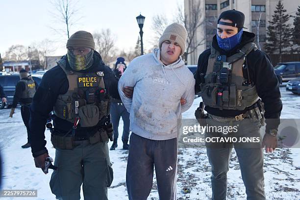 Federal immigration agents detain a man during an operation by US Immigration and Customs Enforcement and Border Patrol in St. Paul, Minnesota, on...