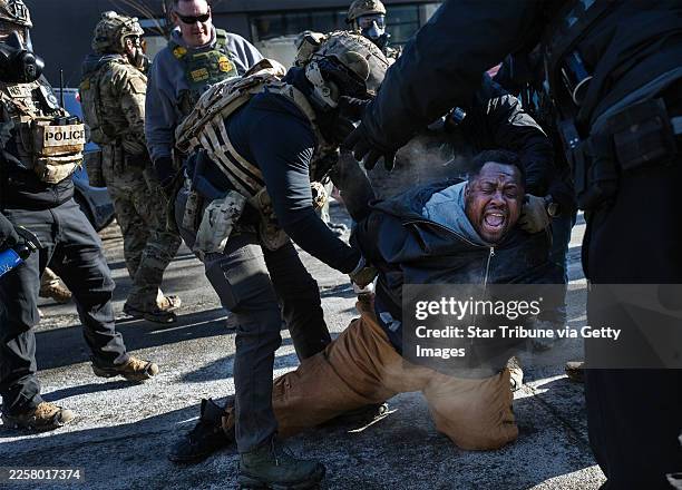 Officers and federal agents clash with a growing crowd of protesters on Nicollet Avenue in south Minneapolis after Alex Pretti was fatally shot by...
