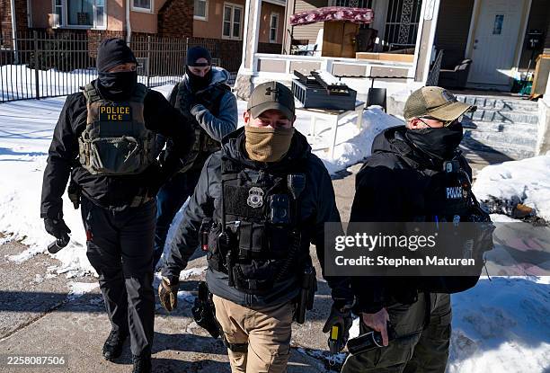 Agents leave a residence after knocking on the door on January 28, 2026 in Minneapolis, Minnesota. The U.S. Department of Homeland Security continues...