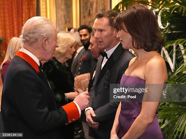 King Charles III speaks to Benedict Cumberbatch and Sophie Hunter in the Grand Reception Room after they attended the premiere of Prime Video's...