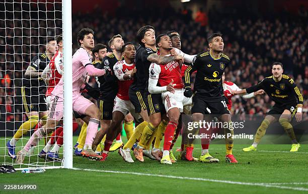 Gabriel of Arsenal is held by Lisandro Martinez of Manchester United for an oncoming corner during the Premier League match between Arsenal and...