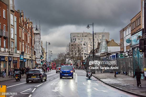 clapham high street on a rainy winter day - clapham stock pictures, royalty-free photos & images