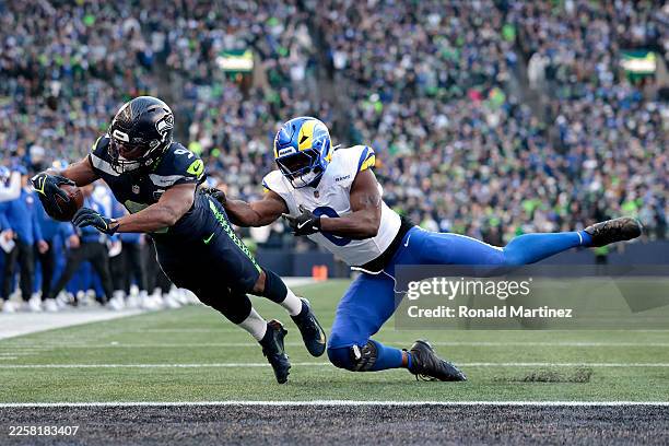 Kenneth Walker III of the Seattle Seahawks scores a first quarter touchdown in front of Byron Young of the Los Angeles Rams in the NFC Championship...