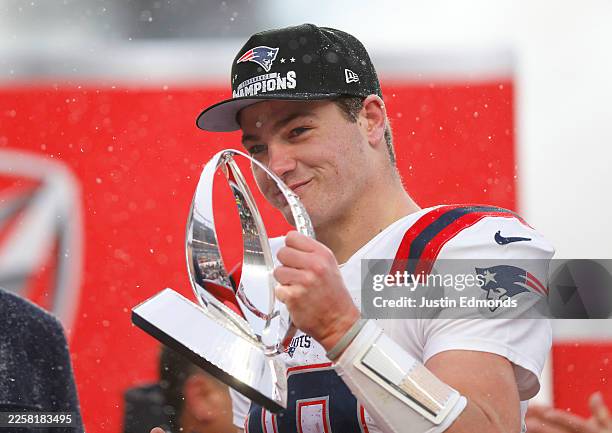 Drake Maye of the New England Patriots celebrates with the Lamar Hunt Trophy during the Trophy Presentation of the AFC Championship Playoff game...