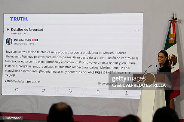 Mexico's President Claudia Sheinbaum speaks next to a projection of a message posted by US President Donald Trump on the social network Truth during...