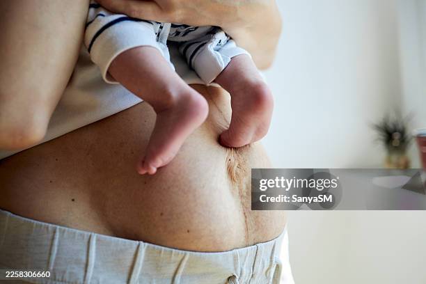 post partum mother body while holding newborn baby - postpartum depression stock pictures, royalty-free photos & images