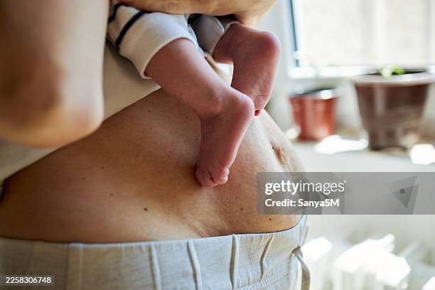 post partum mother body while holding newborn baby - postpartum depression stock pictures, royalty-free photos & images
