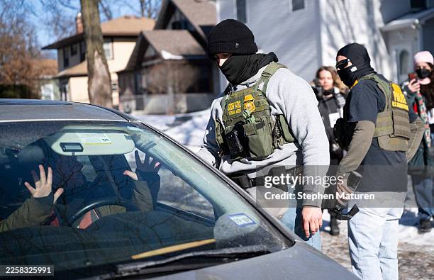Member of the U.S. Border Patrol confronts the driver of a vehicle that was following them on January 29, 2026 in Minneapolis, Minnesota. Protests...