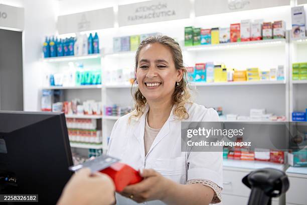 female pharmacist serving female customer at the pharmacy counter - woman at pharmacy stock pictures, royalty-free photos & images