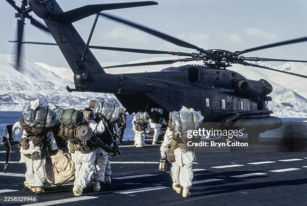 Marines board a helicopter on the USS Saipan during Exercise Teamwork 84, a major NATO winter exercise to reinforce Norway's defence, held above the...