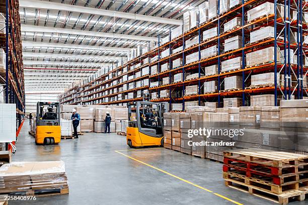 employees working at an e-commerce warehouse and using forklifts - forklift warehouse stock pictures, royalty-free photos & images