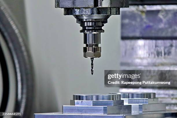 high-precision cnc milling machine drilling metal workpiece in modern industrial factory - metall fräsen stock-fotos und bilder