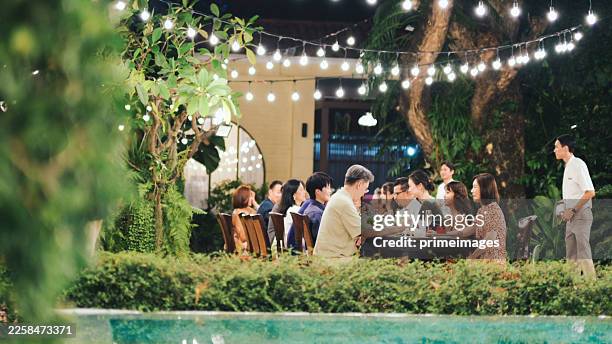 community dining scene large group of asian adults dining together celebrating social connection and lifestyle experience interaction and shared moments - large dinner party stock pictures, royalty-free photos & images