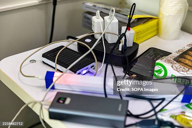 Electronic devices and chargers seen plugged into a power strip at a mobile Solidarity Point. This facility provides electricity during blackouts. A...