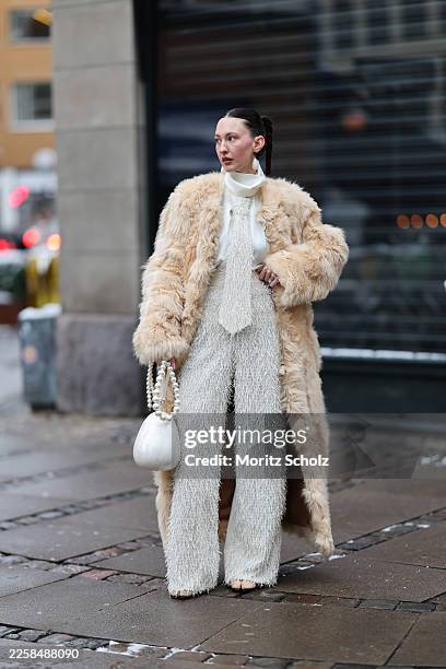 Olha Petrovska is seen wearing a long beige plush fur coat with a straight oversized silhouette and voluminous sleeves from Kulakovsky; underneath a...