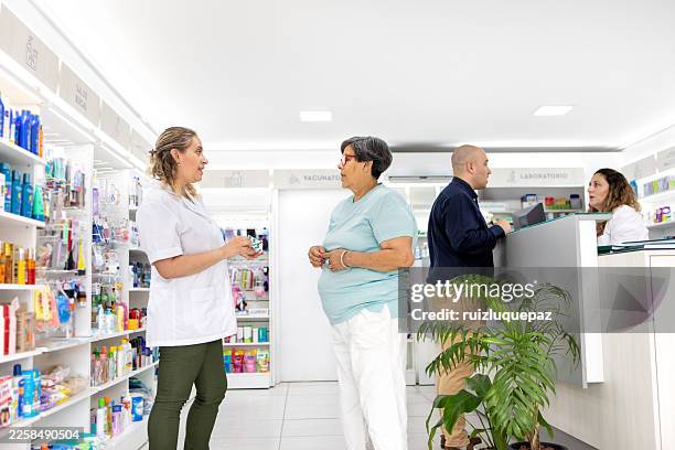 a pharmacist advises an elderly woman on medication in a pharmacy. - woman at pharmacy stock pictures, royalty-free photos & images