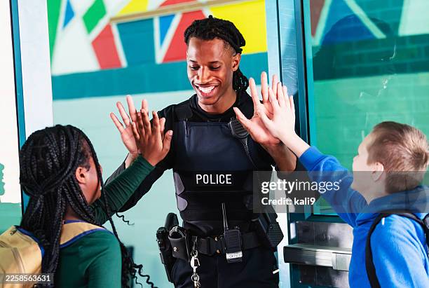 school resource officer greets students arriving at door - police entering stock pictures, royalty-free photos & images