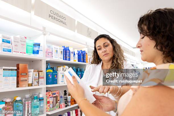 a pharmacist advises a pregnant woman on different products for the future baby in a pharmacy. - woman at pharmacy stock pictures, royalty-free photos & images