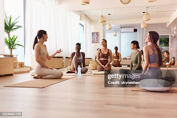 happy diverse women talking on a break in yoga studio. - yoga studio stock pictures, royalty-free photos & images