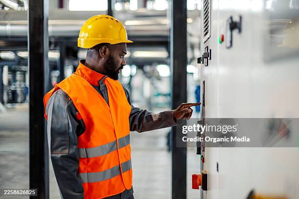 engineer operating industrial control panel in factory - pressing button stock pictures, royalty-free photos & images