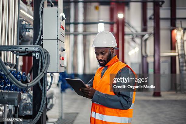 male factory engineer working on digital tablet - computer aided manufacturing stock pictures, royalty-free photos & images