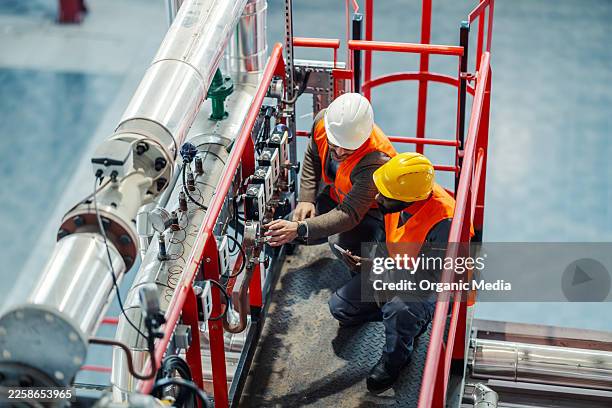 engineers inspecting industrial facility pipeline system - system implementation stock pictures, royalty-free photos & images