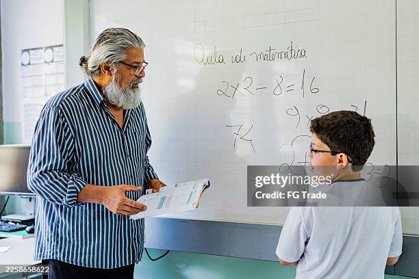 teacher helps student with calculus exercise on whiteboard in the classroom - calculus class stock pictures, royalty-free photos & images