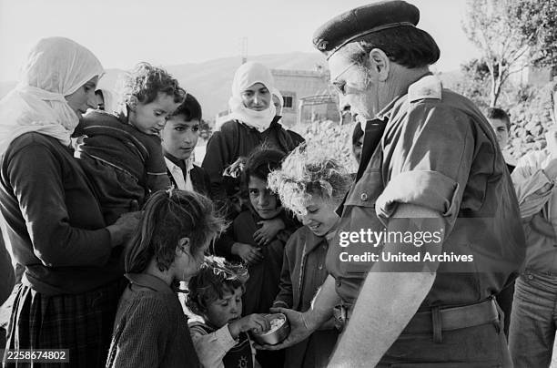 Ein israelischer Offizier verteilt während des Jom-Kippur-Krieges 1973 Süßigkeiten an Kinder in einem syrischen Dorf.
