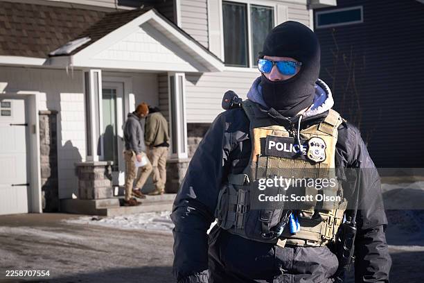 Agents look for someone at a home on January 28, 2026 in Circle Pines, Minnesota. Protests continue around the Twin Cities area after the Trump...