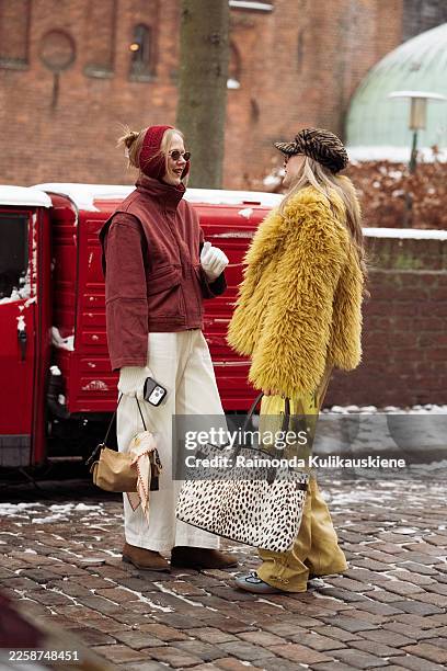 Guest wears a red zip-up jacket with a high collar, white wide-leg trousers, brown suede ankle boots, white knit gloves, a red knit beanie, narrow...