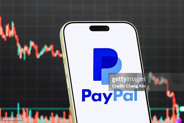 In this photo illustration, a smartphone displays the logo of PayPal Holdings Inc. , an American financial technology company providing digital...